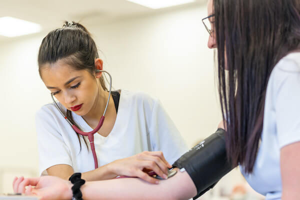 a nurse listens to blood pressure