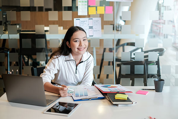 Student sitting at a desk smiling at the camera