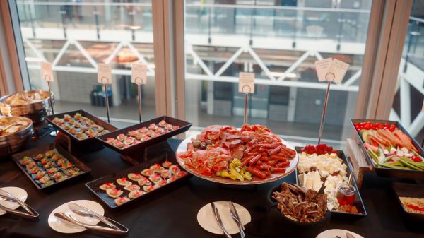 A beautifully arranged buffet display featuring a variety of appetizers, including seafood, desserts, and colorful hors d'oeuvres.