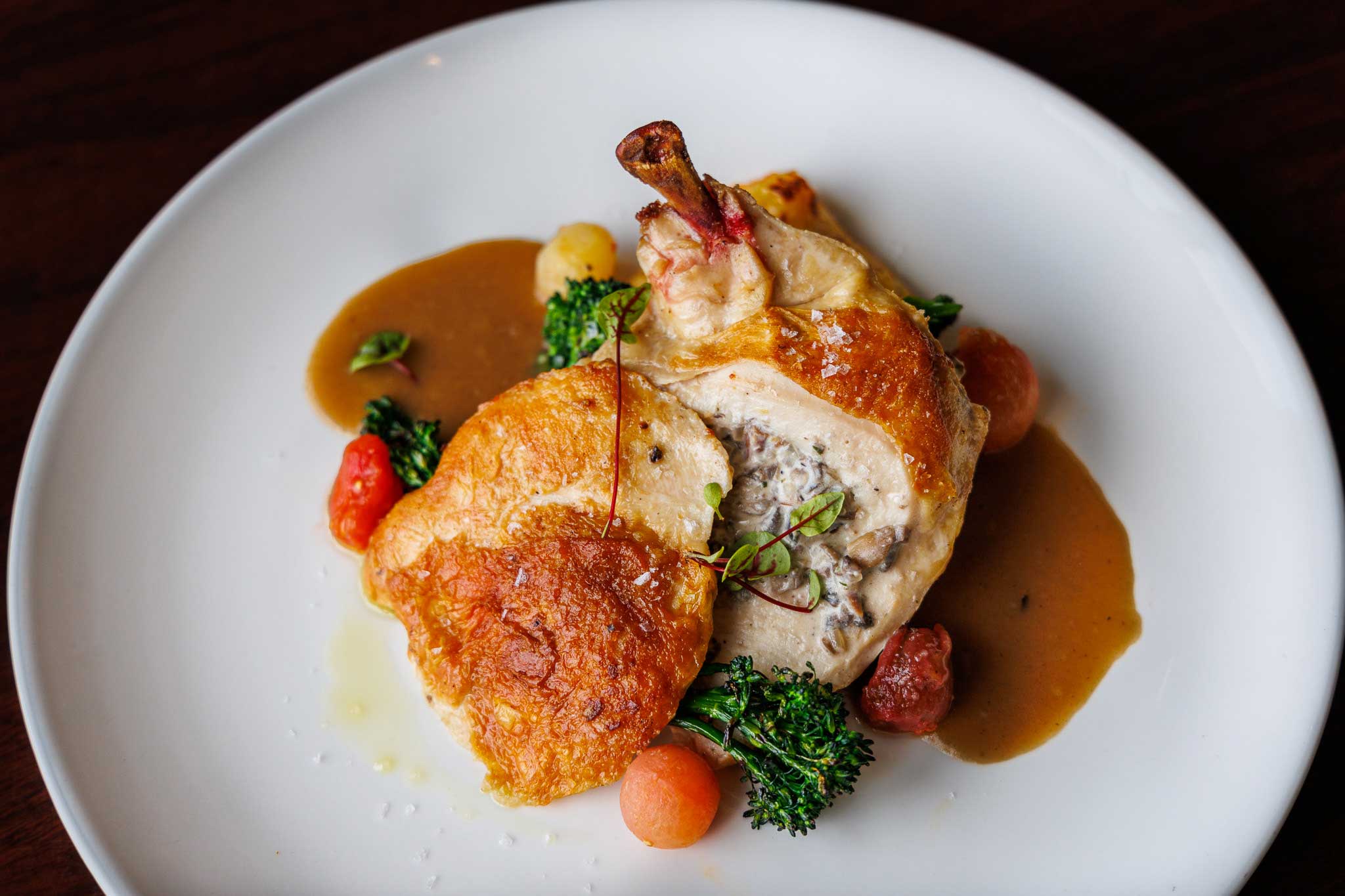 crispy pan-seared quarter chicken stuffed with mushroom, cured ham, and boursin cheese