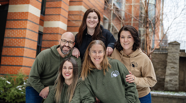 Group of students in hoodies smiling 
