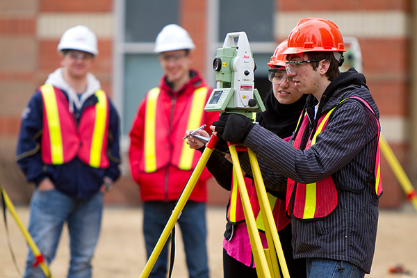 Three SAIT geomatics students survey space on campus.